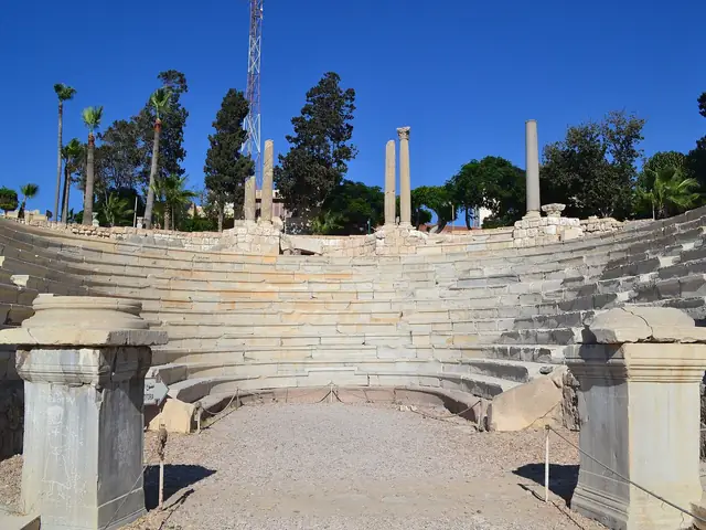 The marble tiers of Alexandria's Roman theatre at Kom el-Dikka, columns and palms against a blue sky
