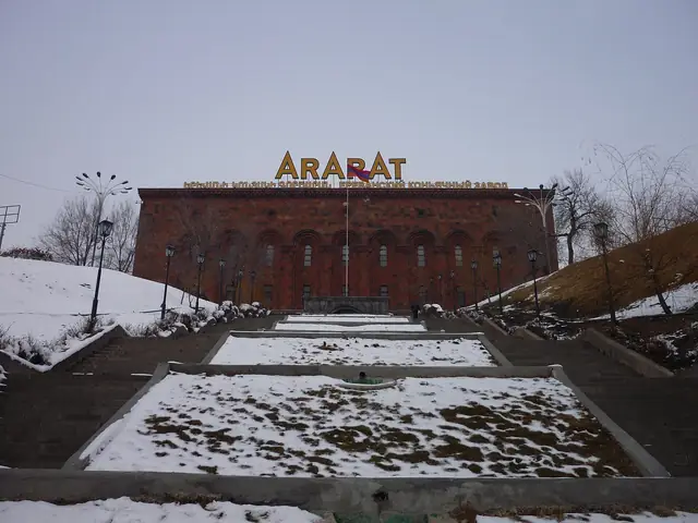 The Yerevan Brandy Company's ARARAT factory building above snowy terraces, winter
