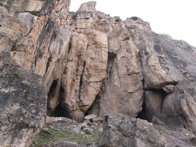 The Areni-1 cave mouth at the foot of a sheer rock face in Vayots Dzor