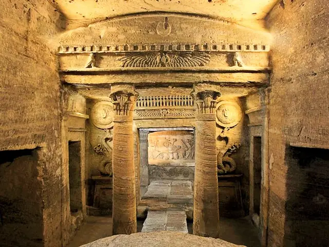 The central tomb inside the Catacombs of Kom el-Shoqafa: carved columns and pediment in warm light