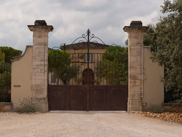 The stone gateposts and wrought-iron gate at the entrance of Château de Beaucastel