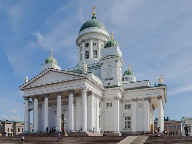 Helsinki Cathedral's white colonnaded front and green domes above the Senate Square steps, blue sky