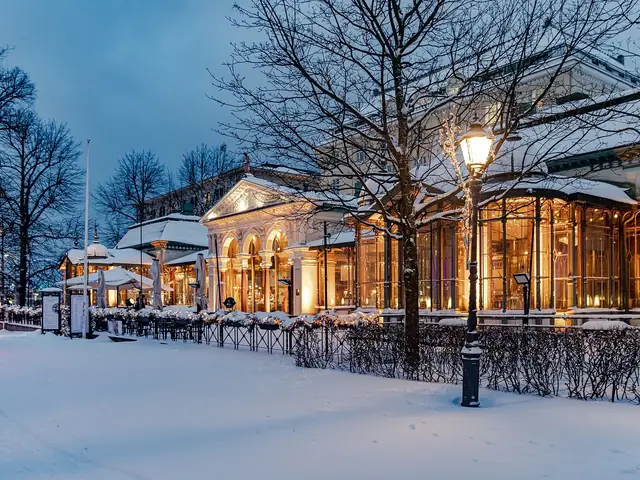 Kappeli's glass-and-iron pavilion lit up on a snowy Esplanadi evening