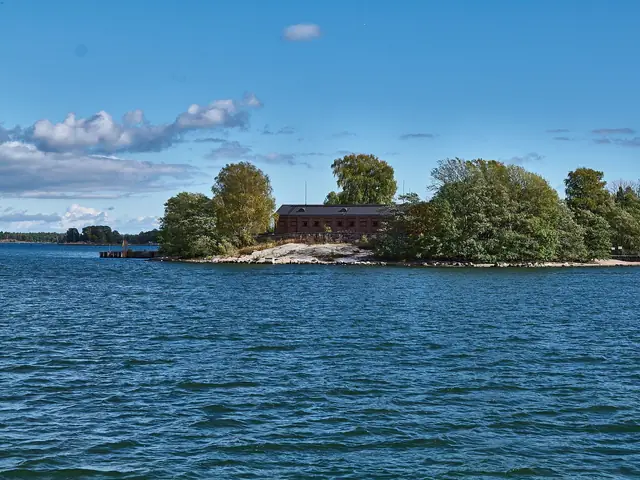 Lonna island seen from the sea: its red-brick buildings among the trees