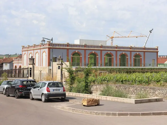 Pressoria in Aÿ: the restored arcaded press house with vines in front
