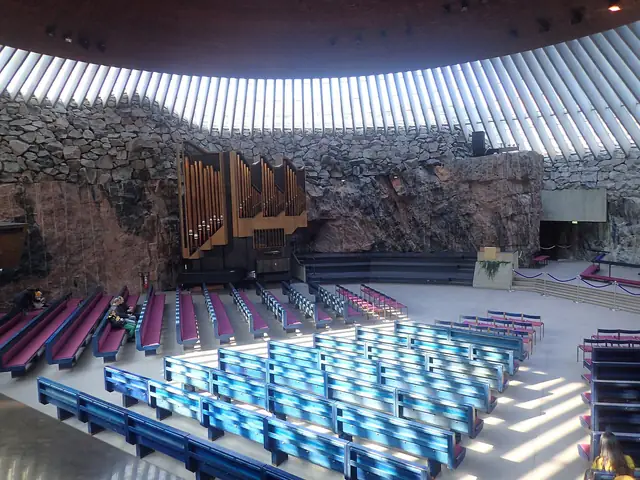 Inside Temppeliaukio Church: the copper dome ringed by skylights over the quarried rock walls and pews