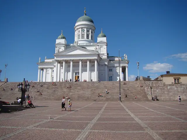 Senate Square's granite paving rising to Helsinki Cathedral under a blue sky