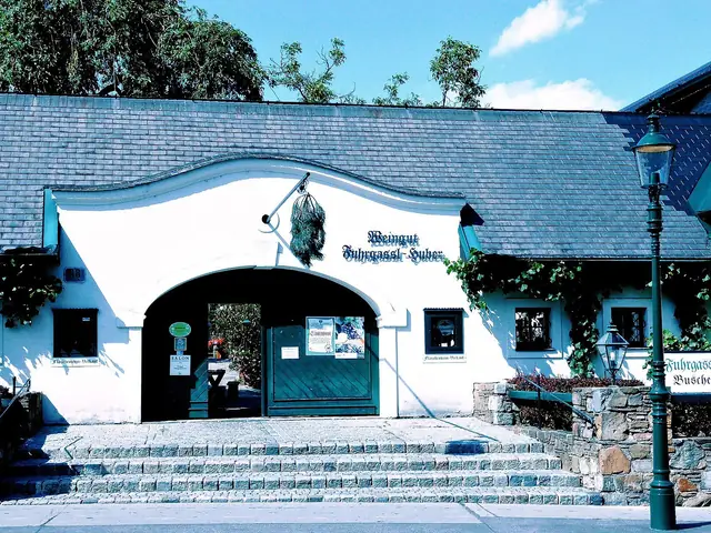 The arched entrance of Weingut Fuhrgassl-Huber, the name painted above the gate, in Neustift am Walde