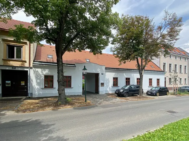 Weingut Wieninger's long white farmhouse frontage on Stammersdorfer Straße under the trees